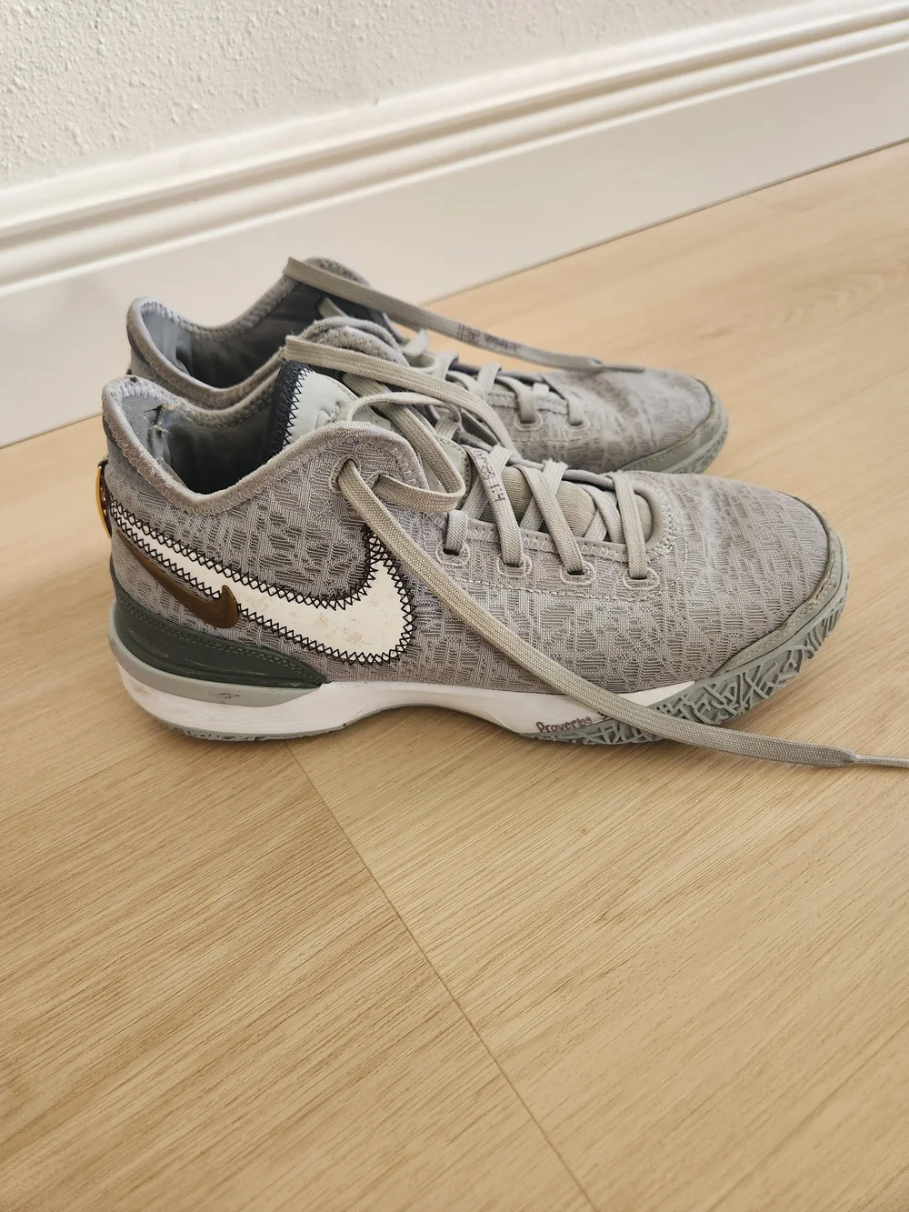 Nike Gray and White Low-Top Sneakers with Gold Swoosh